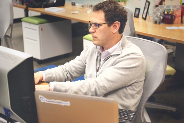 man sitting at his desk and cubicle