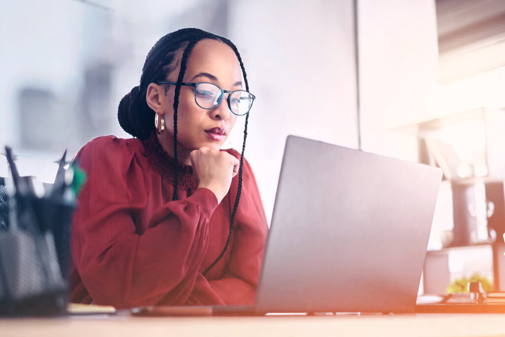 young woman in glasses looking at laptop